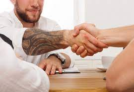  Image of handshake with a professional who has tattoos